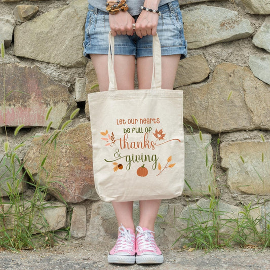 canvas tote bag with fall elements and the phrase "let our hearts be full of thanks and giving"