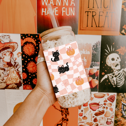 a jar with a Halloween-themed card featuring cats and pumpkins