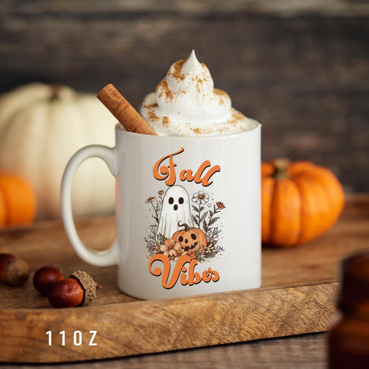 ceramic coffee mug themed with a retro boho ghost and a pumpkin and the phrase "fall vibes"