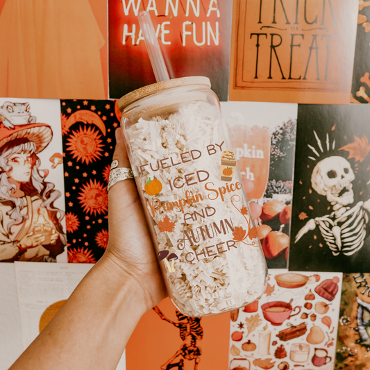 16 oz glass can with lid and straw themed with fall elements and the phrase "Fueled by iced pumpkin spice and autumn cheer"