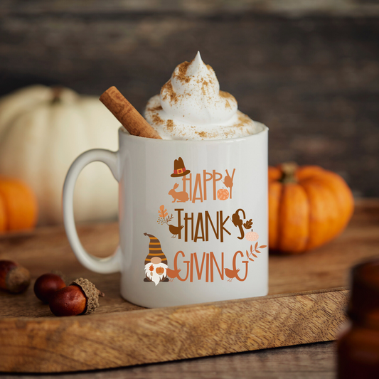 White mug with 'Happy Thanksgiving' text, whipped cream, and a cinnamon stick on a wooden surface with pumpkins in the background.