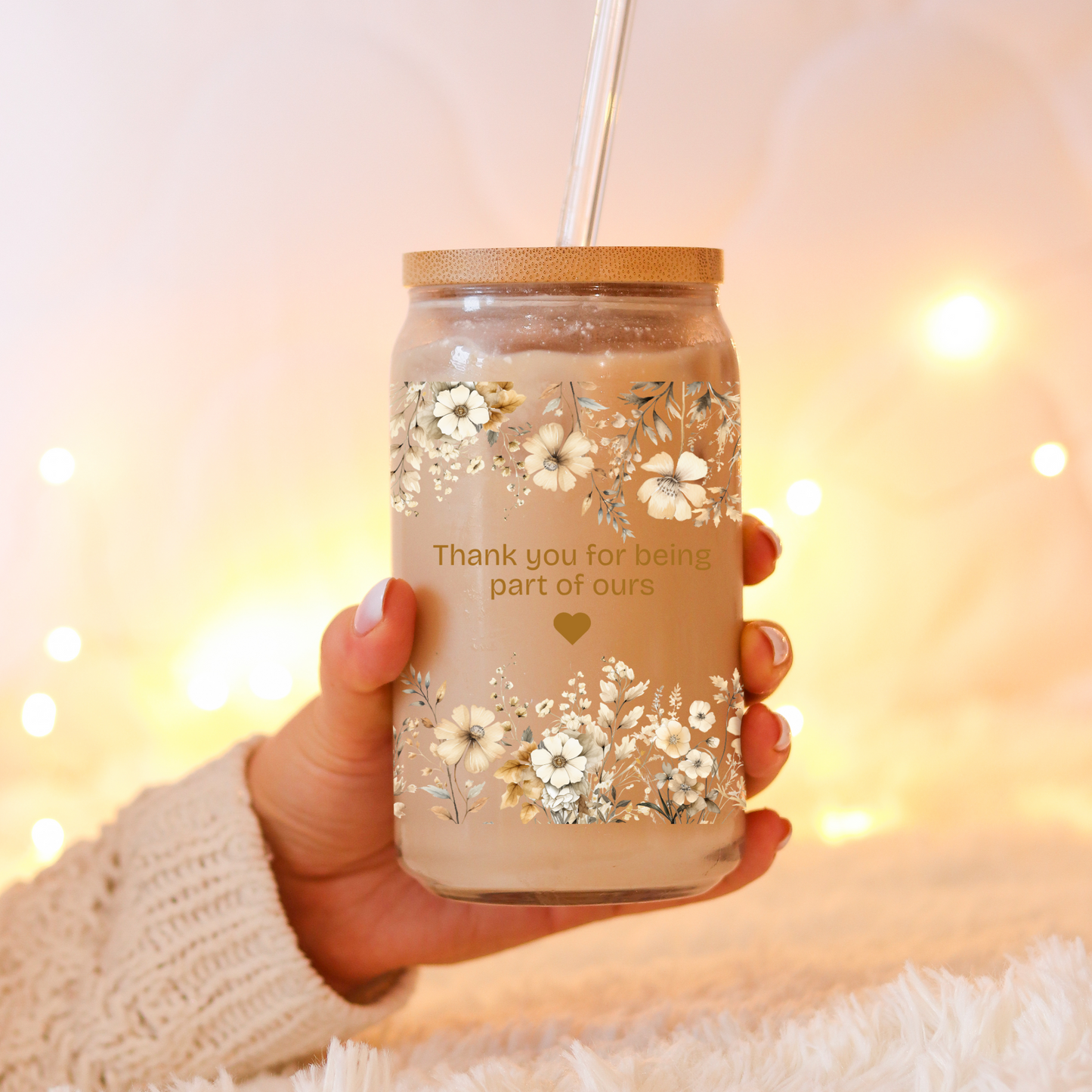Glass jar with lid and straw a cute floral design and the phrase "It takes a village Thank you for being part of ours"